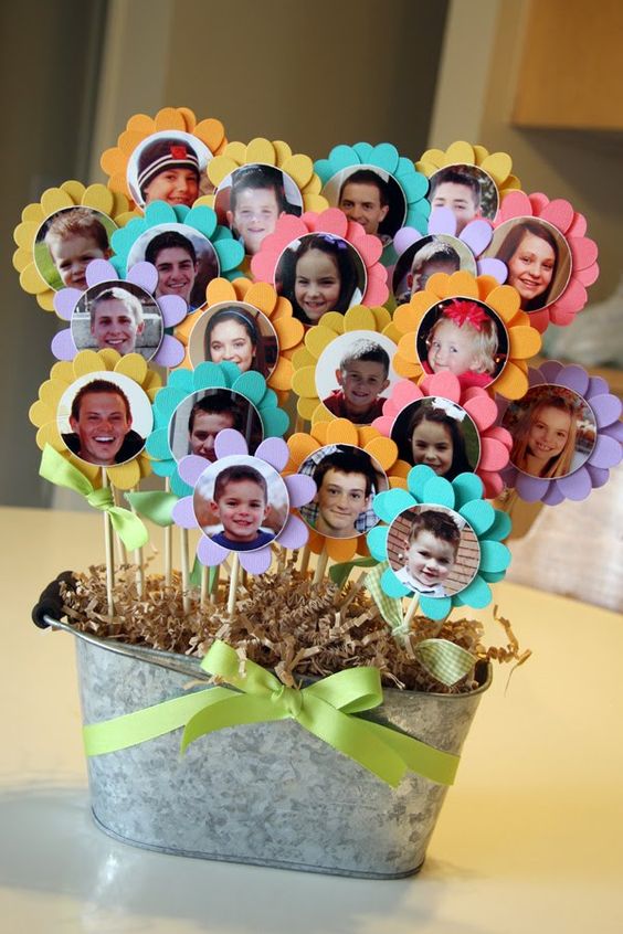 Manualidad con fotos de niños en flores de papel en una maceta