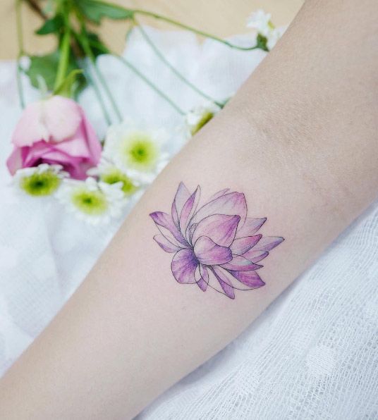 Tatuaje de una flor de loto color rosa en un brazo