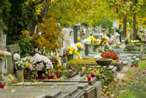 Un cementerio con tumbas llenas de flores en el Día de Todos los Santos